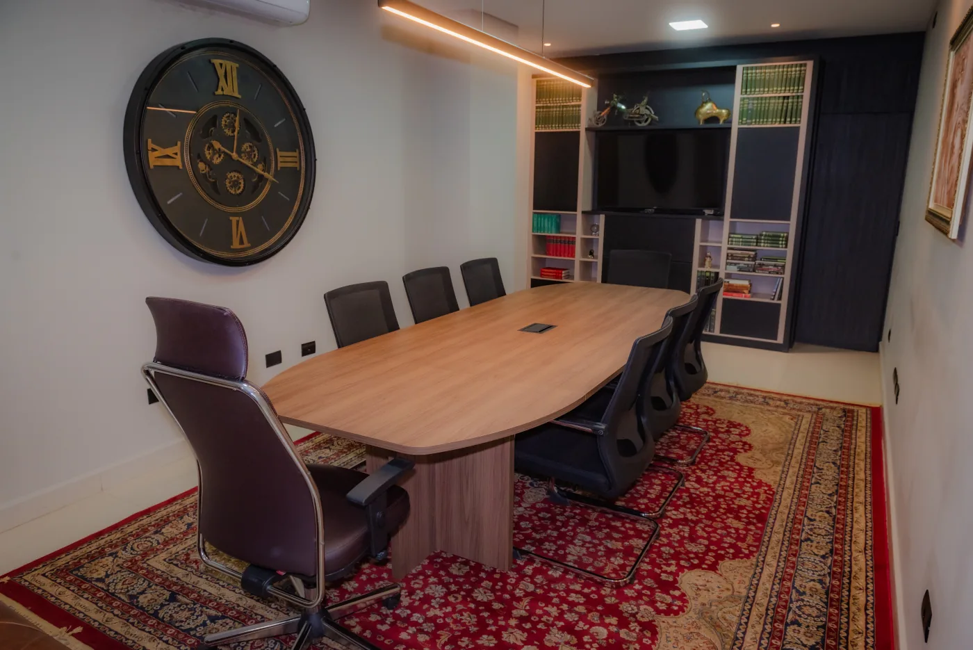 Sala de reuniões do escritório com mesa ampla e biblioteca